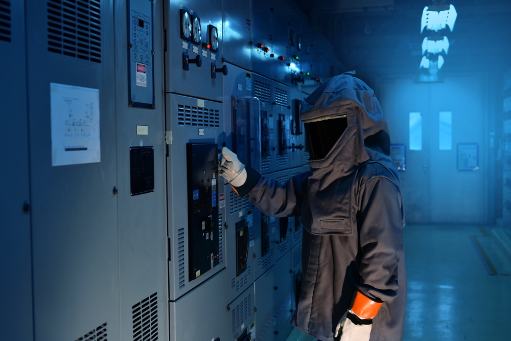 Figure: Electricity worker using personal protective equipment for inspections in electrical panels.